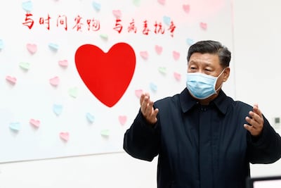 Chinese President Xi Jinping gestures near a heart shape sign and the slogan "Race against time, Fight the Virus" in Beijing. AP