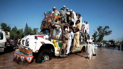 A driver makes his way along a street flooded by heavy rain in Peshawar, Pakistan. Mohammad Sajjad / AP Photo