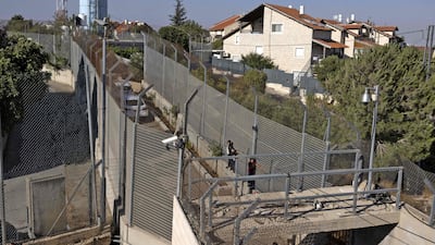 Children of the Gharib family play between Israeli army barriers.