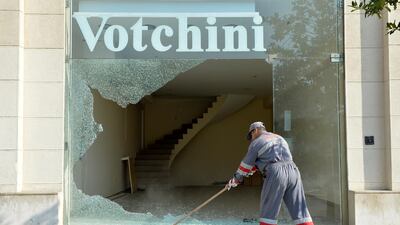 A worker cleans up broken glass of a damaged shop a day after anti-government protests in downtown Beirut, Lebanon, on October 19, 2019. EPA