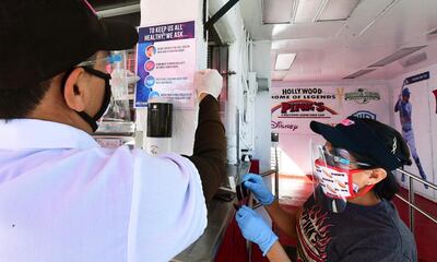 Workers post safety protocols while wearing face shields, masks and gloves at the reopening of a Los Angeles, California, restaurant. AFP