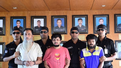 The Bangladeshi Rapid Action Battalion, back row, accompany suspects Touhidur Rahman, left, Sadek Ali, centre, and Aminul Mallick, right, who have been arrested for the murder of two prominent atheist bloggers. Munir Uz Zaman / AFP Photo