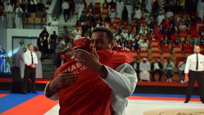 Faisal Al Ketbi gets a hug from the UAE coach Ramon Lemos after winning the 94kg final at the JJIF World Championship at the Mubadala Arena on Friday. Courtesy Shivanna Gowda