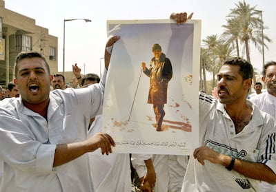 Two Iraqi men hold a picture of former president Saddam Hussein as they shout anti-US slogans in the town of Baquba, 80km north of Baghdad on August 12, 2003. Reuters.