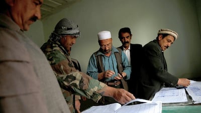 Factory workers sign in their attendance as they arrive for work.