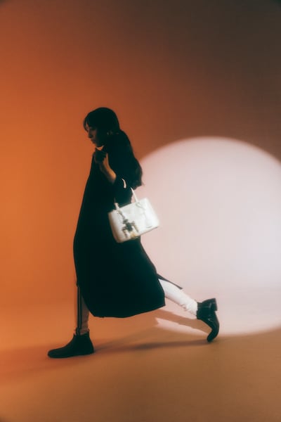 Single-breasted fabric coat; fleece leggings; leather boots; Galleria leather bag; and Robot Saffiano leather key ring charm, all from Prada