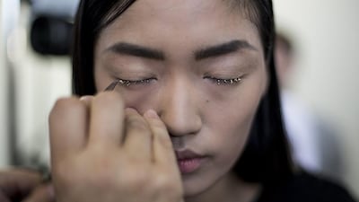 Qiwen Feng has her makeup done backstage prior to the presentation of the Dries Van Noten collection during the Spring/Summer 2014 Ready to Wear Paris Fashion Week. Yoan Valat / EPA