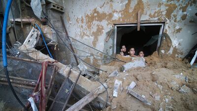 Palestinian children sit among the rubble of a house in Rafah destroyed by Israeli air strikes on the Gaza Strip. AP