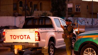 A policeman motions to vehicles passing through a security checkpoint enforcing a curfew due to the COVID-19 coronavirus pandemic in Iraq's southern city of Basra during the Muslim holy fasting month of Ramadan on April 30, 2020. AFP