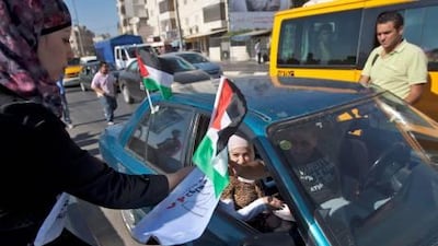 Activists of the Palestine 194 campaign distribute flags and leaflets to motorists in order to drum for Palestine to become the 194th state recognised by the UN, in the West bank town of Ramallah. ATEF SAFADI / EPA