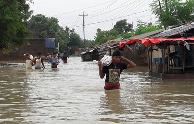 Nepalese residents wade through floodwaters at Janakpur, some 300km south-east of Kathmandu on August 13, 2017. Sajan Malla/AFP Photo
