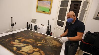 Maamary examines a 17th-century painting by Italian painter Elena Recco, damaged in the Beirut port blast.
