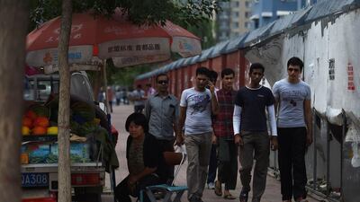 Pakistani refugees and asylum seekers (from left) Mahdi, Waheed Ahmad, Yasir Chaudry (obscured), Sarim, Asif Mangla and Moeed walk down a street in Sanhe, China’s Hebei province. They are members of a minority sect in Pakistan that have fled discrimination and violence and found unlikely refuge in China. Greg Baker/AFP Photo