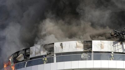 Civil defence workers fight the fire that has broken at The Address skyscraper in Downtown Dubai during the New Year's Eve. Sunday Alamba / AP Photo