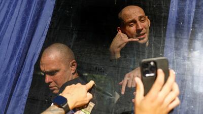 Freed Ukrainian prisoner of war (POW) Oleksii Ihnatenko gestures as his friend Pavlo holds a phone with video call from Oleksii’s mother, after a swap, amid Russia's attack on Ukraine, in an undisclosed location in Ukraine, August 14, 2025. REUTERS / Valentyn Ogirenko TPX IMAGES OF THE DAY