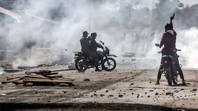 Kenyan police officers brandish pistols during clashes in Nanyuki, near the site of a planned quarantine facility. AFP