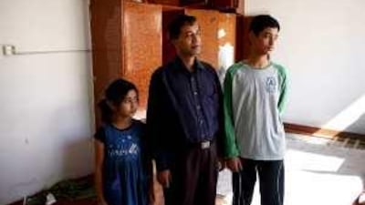 Gulzar Hossain, with his daughter Shaima, seven, and son Humayun, 12, visits the villa that was their home for 10 years. The building is scheduled for demolition.