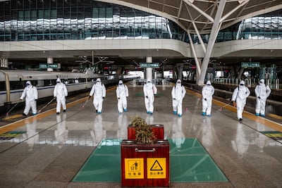 Staff members spray disinfectant at Wuhan Railway Station in Wuhan, China. STR / AFP