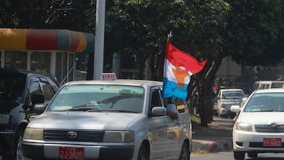 Myanmar military supporters riding a vehicle wave a military flag as they go around Yangon, Myanmar. AP