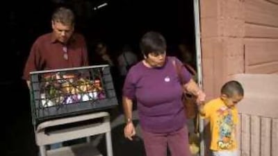 Ron Sheldon, left, a volunteer at the Phoenix Rescue Mission, helps Sally Nieto carry groceries from the food bank.
