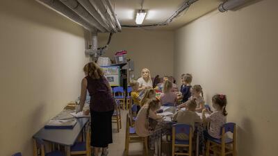 Children and their teachers wait in a kindergarten basement used as a bomb shelter during an air strike alarm in Kryvyi Rih, southern Ukraine. AFP