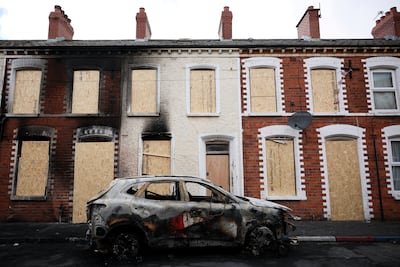 A burnt car in front of a boarded up house in the aftermath of anti-immigrant protests in Belfast. Reuters