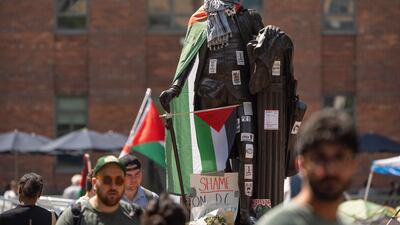 Stickers and Palestinian flags cover a statue of George Washington at an encampment by students protesting against the Israel-Gaza war at George Washington University. AP