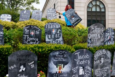Jayde Newton helps to set up cardboard gravestones with the names of victims of opioid abuse outside a New York courthouse during a Purdue Pharma bankruptcy hearing in 2021. AP