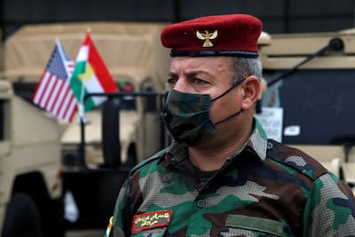 A Kurdish peshmarga wears a mask as he attends a distribution ceremony of military aid by US army to Kurdish fighters in Erbil in 2020. Reuters