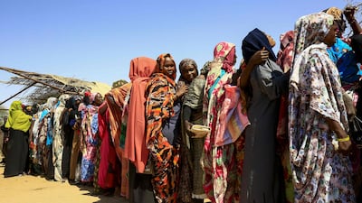 Displaced Sudanese women wait for the arrival of the World Food Programme aid in an internally displaced people's camp on the outskirts of Nyala, capital of South Darfur. AFP