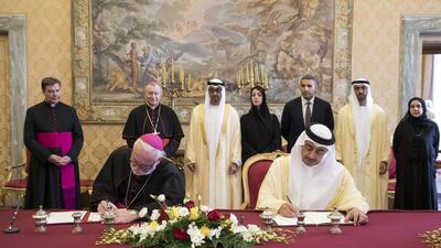 Sheikh Mohamed bin Zayed, back third left, watches as Sheikh Abdullah bin Zayed, Minister of Foreign Affairs and International Cooperation, signs a memorandum of understanding with Archbishop Paul Gallagher, Vatican Secretary for Relations with States. Watching them are Cardinal Pietro Parolin, Vatican Secretary of State, back second left, Reem Ibrahim Al Hashimi, Minister of State for International Cooperation, back fourth left, Khaldoon Khalifa Al Mubarak, CEO and Managing Director, Mubadala, and Chairman of the Abu Dhabi Executive Affairs Authority, back fifth left, Mohammed Mubarak Al Mazrouei, Undersecretary of the Crown Prince Court of Abu Dhabi, back sixth left, and Dr Hessa Al Otaiba, UAE Ambassador to Spain and Non-Resident Ambassador to the Vatican, back right. Ryan Carter / Crown Prince Court - Abu Dhabi