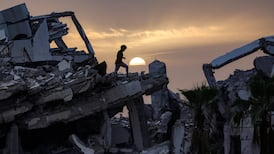 A young Palestinian man walks along the ruins of a destroyed building in the Zahra neighbourhood, south-west of Nuseirat in the central Gaza Strip. AFP