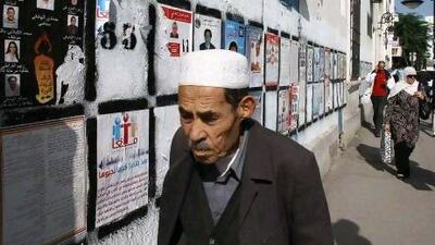 Tunisians pass election wall posters in Tunis last October. Ahmed Bouazzi, of the Progressive Democratic Party, says one mistake the party made was to heed the advice of campaign consultants to plaster walls with posters of party leaders, recalling Ben Ali’s once ubiquitous portraits.