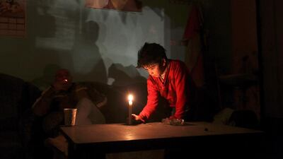 A Palestinian boy waits to have his hair cut in a Palestinian refugee's barber shop during a power outage in Al Shateaa refugee camp in Gaza City. Mohammed Saber / EPA