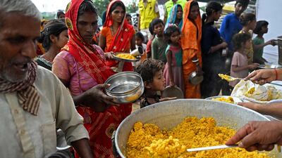 People queue for food at a temporary shelter in New Delhi. AFP