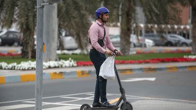 A man travels through the rain on an e-scooter.
