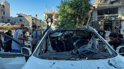 Palestinians inspect a vehicle in Gaza city where Al Jazeera said two of its journalists were killed in an Israeli strike. Reuters