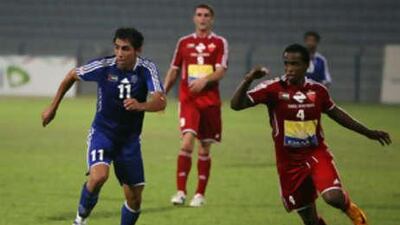 Mehrzed Madanchi of Al Nasr, in blue, and Edris Fawzi of Al Ahli, no 4 in red, in action during the football match at Al Nasr football ground in Dubai.