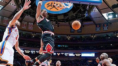 The Chicago Bulls guard Derrick Rose stuffs the ball past New York Knicks forward Jared Jeffries, left, in the first quarter. Ray Stubblebine / AP Photo