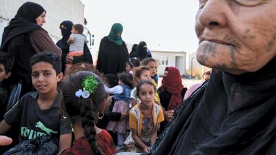 Displaced Iraqis prepare to board a bus at a camp for displaced people in Hammam al-Alil, south of the northern Iraqi city of Mosul, on August 27, 2019, as they are transferred back to Kirkuk province. AFP