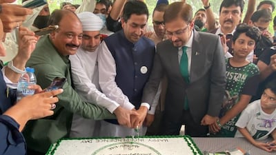 Pakistan officials and residents cutting a large cake to celebrate the day.