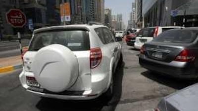 A parked car blocks in another vehicle on Hamdan Street yesterday.