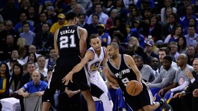 Tony Parker of the San Antonio Spurs dribbles around a screen set by Tim Duncan on Tuesday night during their NBA win over the Golden State Warriors. Ezra Shaw / Getty Images / AFP / November 11, 2014