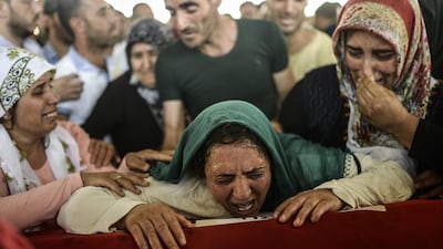 The mother of a victim cries for her son on his coffin during a funeral ceremony in Gaziantep on July 21, 2015, following a suicide bomb attack the day before which killed at least 32 in the southern Turkish town of Suruc. Bulent Kilic/AFP Photo