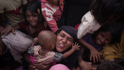Rohingya Muslim refugees react as police and officials attempt to control a surging crowd as they wait to be called to receive food aid of rice, water, and cooking oil at a relief centre at the Kutupalong refugee camp in Cox's Bazar. Ed Jones / AFP Photo