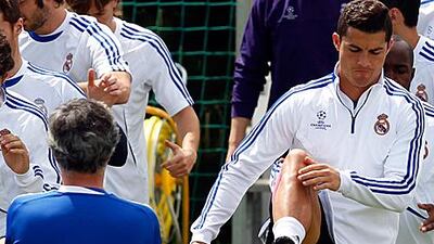 Real Madrid's Cristiano Ronaldo, right, warms-up beside coach Jose Mourinho at training yesterday.