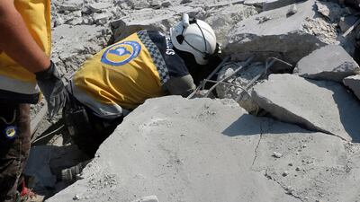 A Civil Defence worker searching for victims from under the rubble of a destroyed building that hit by airstrikes in Deir Al Sharqi village in Idlib province Syrian Civil Defense White Helmets via AP
