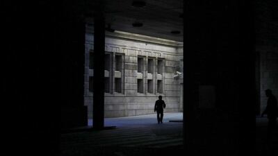 A man walks at the Bank of Japan headquarters in Tokyo. The world's third-largest economy had been forecast to rebound by 2.1 per cent, but consumption and exports remained weak, saddling companies with huge inventories to work off. Yuriko Nakao / Reuters