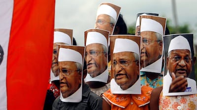 August 18, 2011: Supporters ofAnna Hazare wearing portraits of Hazare attend a protest against corruption next to the Indian national flag in Agartala, capital of India's northeastern state of Tripura. REUTERS/Jayanta Dey