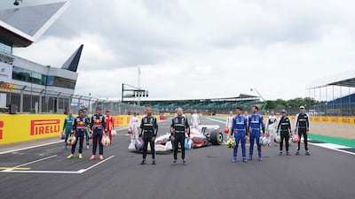 Drivers pose with a model of the 2022 F1 car revealed in 'F1 One Begins' event at the Silverstone circuit. F1 will introduce a new rules and regulations in 2022.